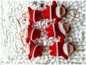 Detail of six plush Santa Claus ornaments with gold strings on a snowy white background