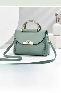 Dettaglio borsa a mano verde grigio con manico dorato e inserti in pelle intrecciata