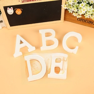 Detail of white wooden decorative letters A to E for home decor and wedding photo props