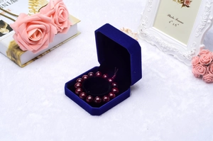 Detail of red bead bracelet inside an octagonal royal blue velvet jewelry gift box