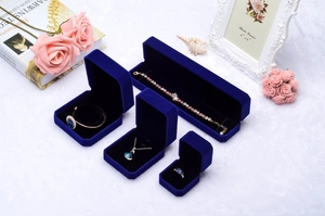 Collection of royal blue velvet jewelry boxes for rings and necklaces on white decor