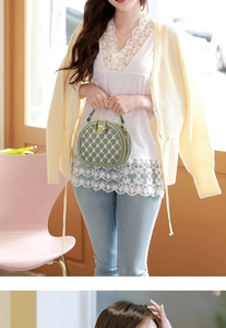 Detailed close-up of a green round crossbody bag with letter print and gold hardware