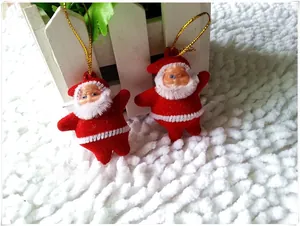 Detail of red flocked Santa Claus ornaments with gold strings on white plush background