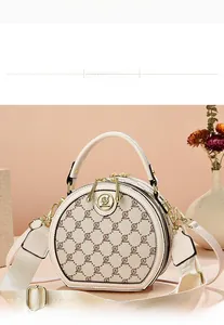 Detail view of round crossbody bag with vintage monogram and gold logo buckle