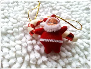 Close-up of red flocked Santa ornament and candy cane decoration with gold string
