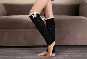 Close-up of black cable knit leg warmers with white lace trim and decorative buttons