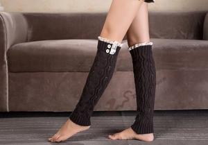 Detail of coffee brown knit leg warmers with delicate white lace trim and round buttons