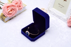 Close-up of royal blue velvet octagonal jewelry box with rose gold blue sapphire ring