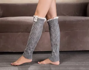 Close-up of gray knit leg warmers with leaf pattern, white lace trim and buttons