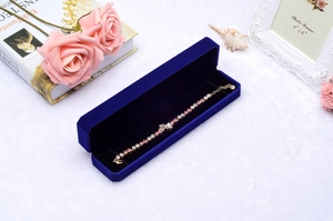 Gold chain bracelet with pink and white zircon stones in a royal blue velvet gift box