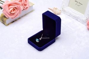 Elegant blue swan necklace displayed in a luxury navy velvet jewelry box with floral accents