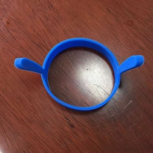 Blue silicone round egg mold with dual side handles on a dark wood background