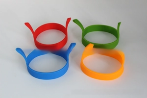 Detailed view of four colorful silicone egg rings with heat-resistant handles