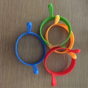 Detail view of four-color silicone egg rings with lifting handles for pancake cooking