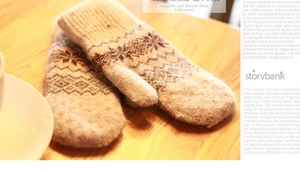 Detailed knit texture of warm winter mittens with Nordic snowflake patterns on a table