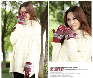 Close-up of red rabbit wool mittens with Nordic snowflake patterns and white knit sweater