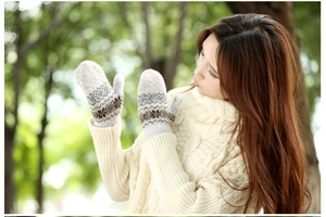 Detail of Nordic wool mittens with snowflake patterns in a winter outdoor setting