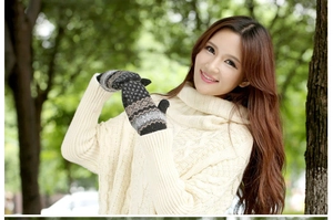 Detail of thick winter knit mittens with grey geometric jacquard pattern for women