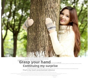 Outdoor close-up of knitted mittens featuring ethnic snowflake patterns and ribbed cuffs