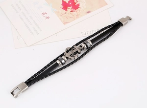 Detail of multi-layer black braided leather bracelet with metal anchor and silver beads