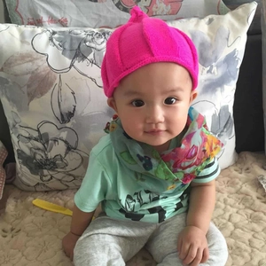 Detail of ribbed knit texture on a rose pink pointed baby hat for toddlers