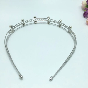 Close-up of silver metal double-layered headband with white pearls and sparkling rhinestones
