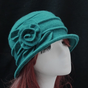 Detailed view of turquoise wool felt cloche hat with an elegant 3D floral decoration