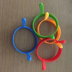 Set of four colorful silicone egg rings with double handles on a rustic wooden table