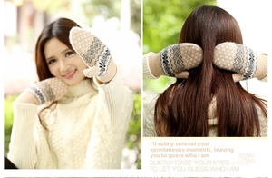 Detail of khaki knit mittens with snowflake pattern and convenient hanging string