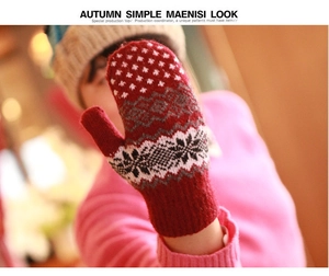 Detail of red Nordic snowflake knit mittens with warm thick winter patterns on hands