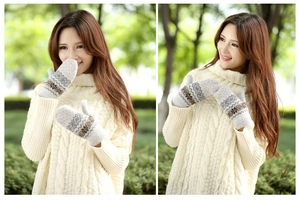 Detail of warm grey knit mittens with nordic snowflake patterns and ribbed cuffs