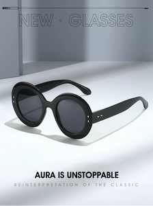Détails de lunettes de soleil ovales noires avec rivets dorés et verres anti-UV sombres