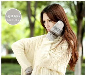 Detail of light grey thermal knit mittens with dark snowflake and ethnic patterns