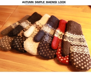 Detail of warm knit mittens featuring snowflake patterns and festive wave textures