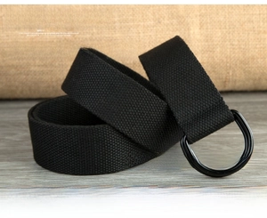 Detail of black canvas belt featuring durable double D-ring metal buckle on rustic wood