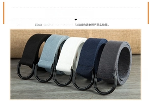 Multi-color canvas belts with matte black double D-ring buckles on a wooden table