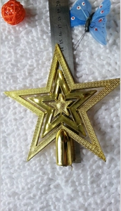 Detailed view of a 20cm gold hollow star tree topper with measuring ruler for size scale