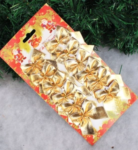 Détail de 12 nœuds de Noël dorés à texture métallique sur un emballage en carton