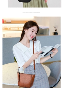 Close-up of caramel brown leather shoulder bag with zipper detail on a fashion model