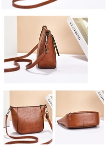 Detailed close-up showing the premium brown PU leather texture and gunmetal zippers of the bag