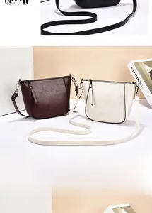 Detailed view of the lychee texture faux leather and dark hardware on the crossbody bag