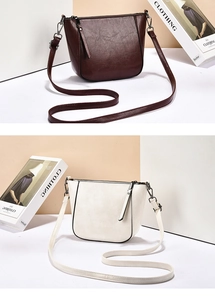 Detail view of large capacity tote bag showing deep brown and cream white leather finishes