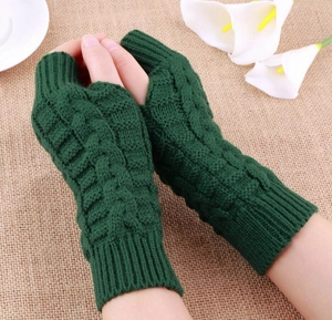 Detail of dark green cable knit fingerless gloves showing texture and wrist coverage