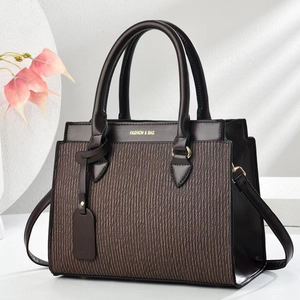 Gros plan du sac à main marron foncé avec texture plissée verticale et détails dorés