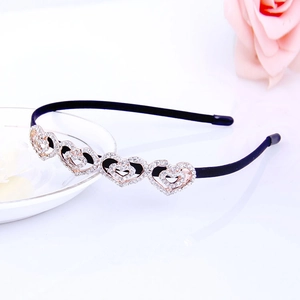 Detailed close-up of rhinestone heart embellishments on a black rhinestone headband