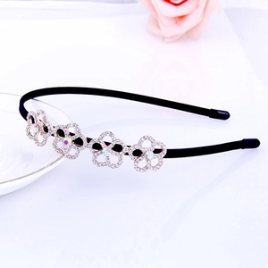 Detail showing four rose gold rhinestone flower charms on a thin black headband accessory