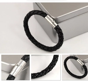 Detail view of black braided leather bracelet texture and silver magnetic clasp closure