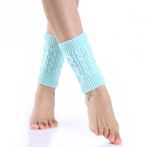 Close-up of mint green cable knit leg warmers showing detailed woolen texture and pattern
