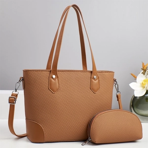 Detailoverzicht van geweven karamel shopper tas met bijpassend tasje en zilveren gespen