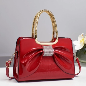 Elegant red patent leather handbag with bow decoration and crocodile pattern